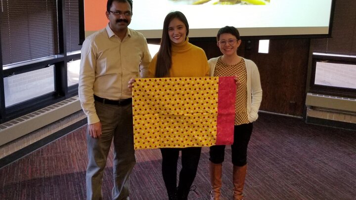 Mariana Sanchez receives insect-themed pillow case at the Department of Entomology graduation ceremony.